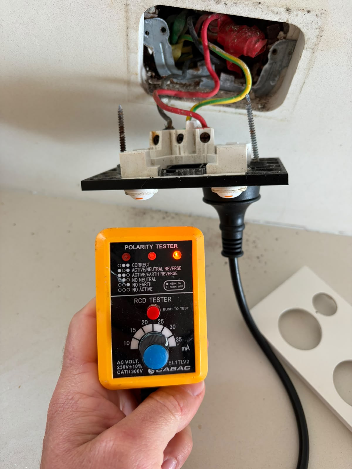 Electrician testing RCD polarity and safety at a Gold Coast switchboard